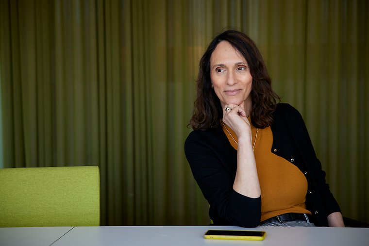 Kvinna som sitter vid ett bord i ett konferensrum.